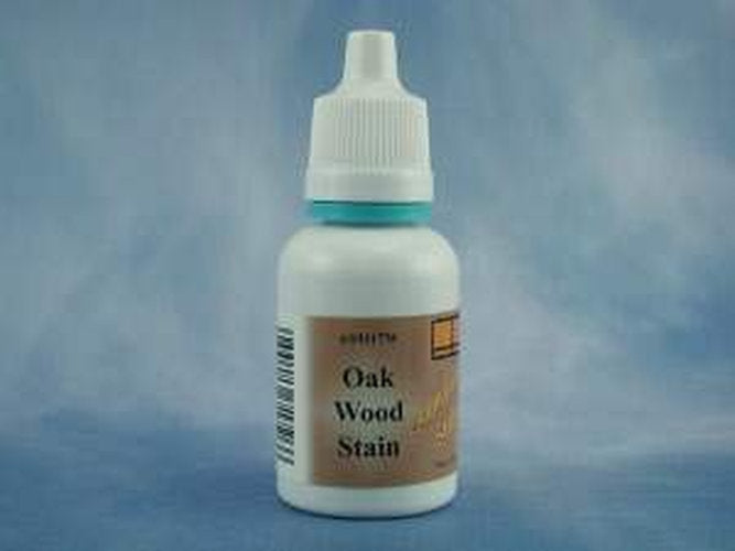 A small white plastic bottle of Oak Wood Stain with a white dropper cap and a tan label, set against a mottled blue background.