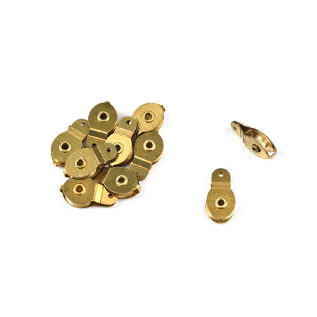 A set of small brass-colored metal hardware pieces, including several flat oval washers and two hook-shaped clips, arranged on a plain white background.